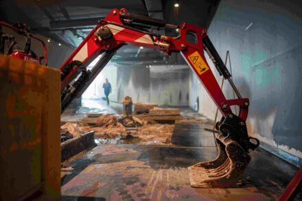 Een graafmachine is aan het werk in de onderdoorgang van het museum