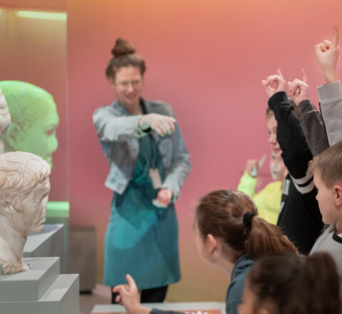Kinderen krijgen een rondleiding van een museumdocent