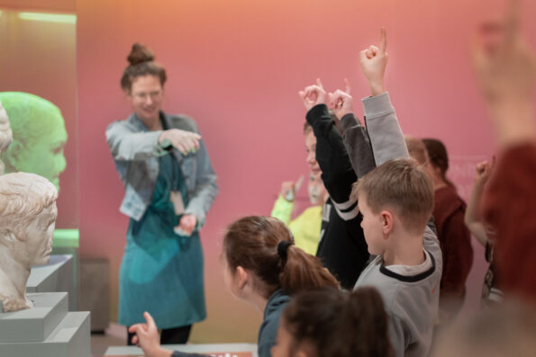 Kinderen krijgen een rondleiding van een museumdocent